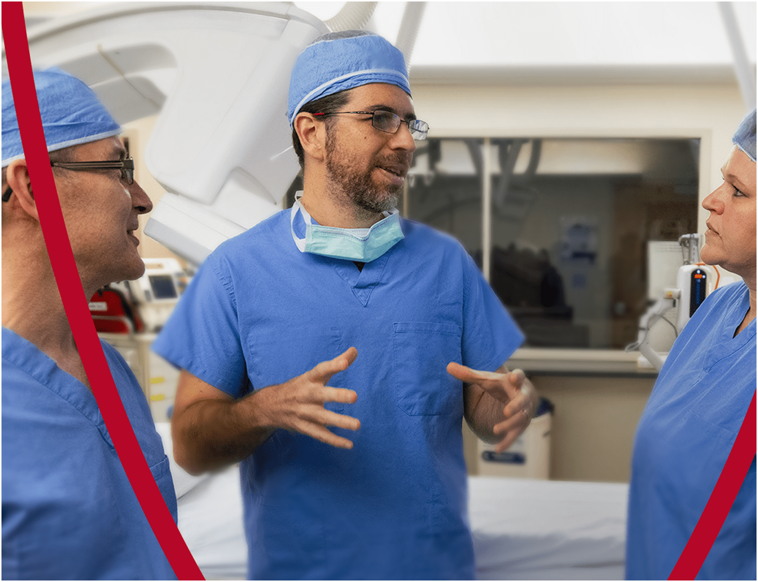 A group of healthcare professionals in blue surgical scrubs engaged in discussion in a medical setting.