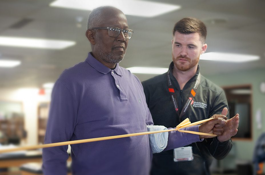 A healthcare professional assists a patient in a physical therapy session using resistance bands.