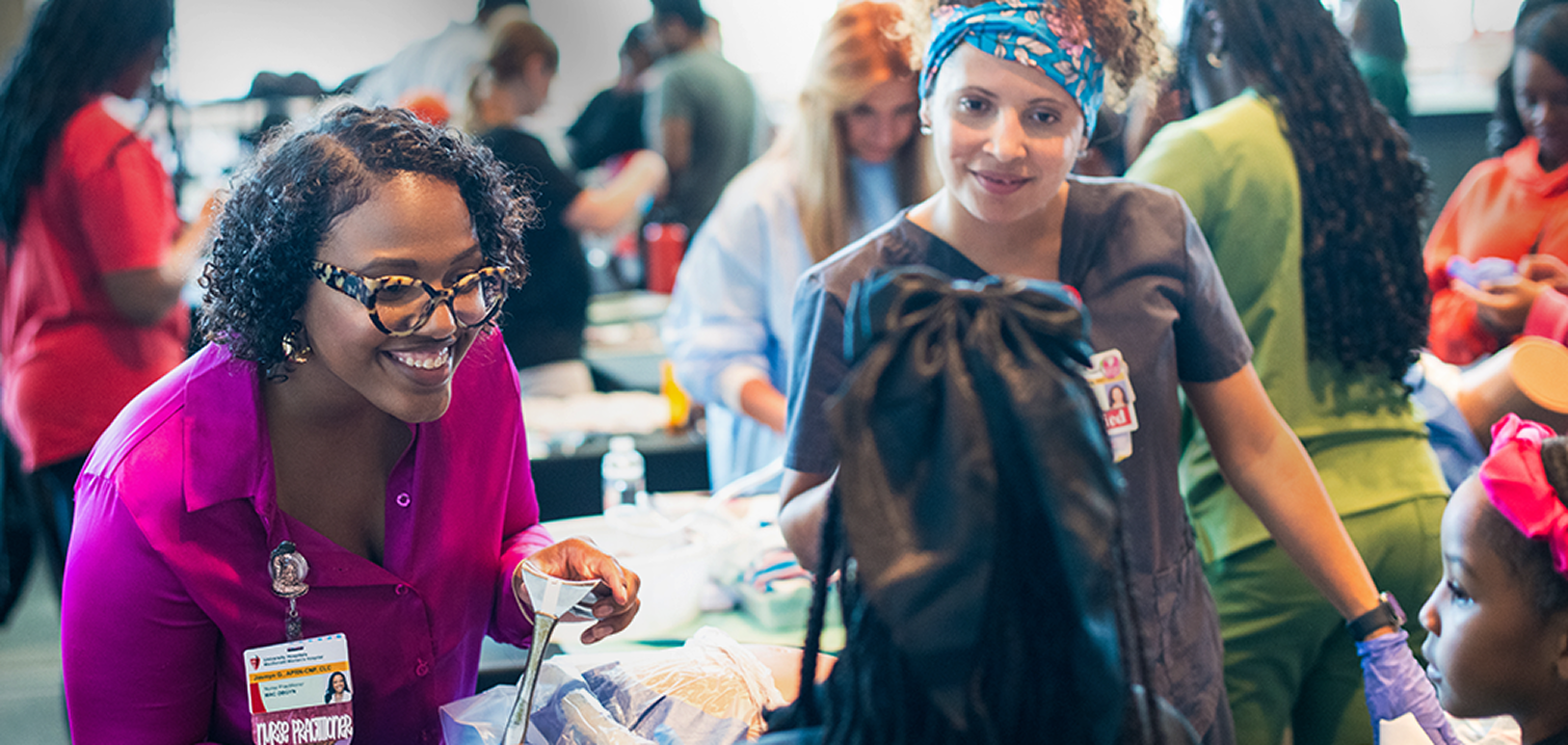 Healthcare professionals engage with potential job candidates at a recruitment event.
