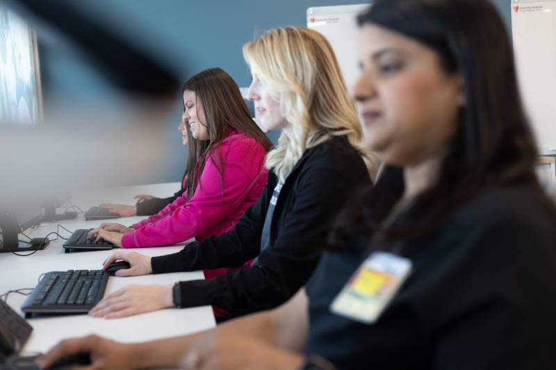 image (22) Healthcare professionals at a busy hospital reception desk assist colleagues and coordinate patient care.